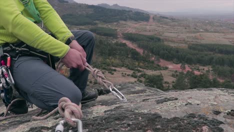 rock climber fixing a rope on a carabiner and securing it before climbing