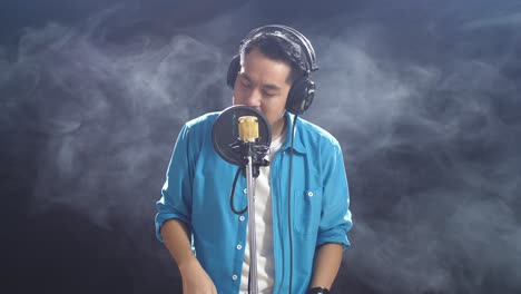 man singing into microphone in recording studio