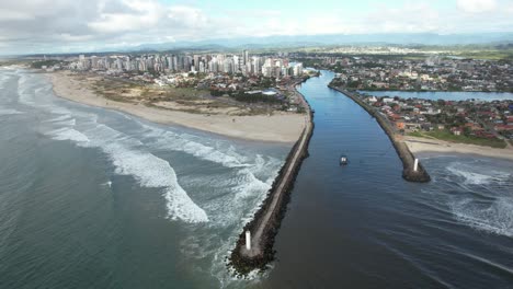 drone shot in orbital motion showing a beautiful canal near the sea, navy lighthouse