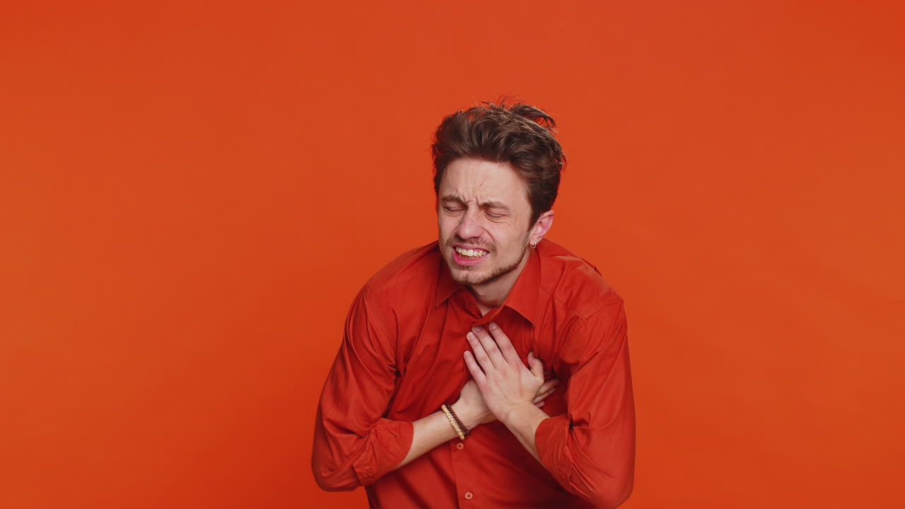 스트레스를 받는 병든 젊은이가 심장통과 함께 가을 붙잡고 긴장해서 고통받고 뇌졸중의 위험이 있습니다.