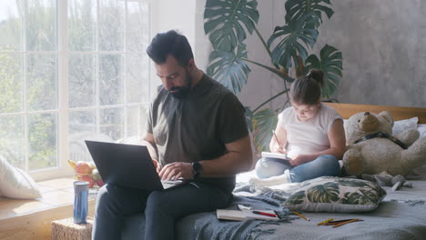 father and daughter working and studying from home