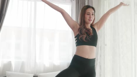 아시아 여성들은 거실에서 요가 운동과 스트레칭으로 휴식을 취합니다