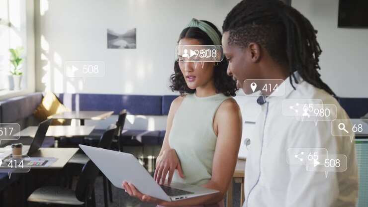 Woman tapping laptop while man watching, likes and comments increasing for social metrics review