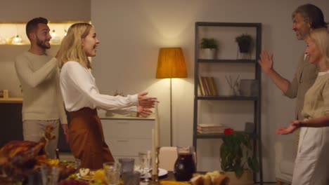 amigos reunidos en casa con mesas con comida deliciosa en acción de gracias