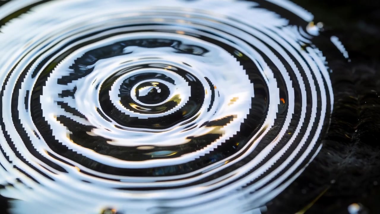 Goccia che colpisce l'acqua di una piscina poco profonda, creando increspature circolari, causando un rimbalzo e riflessi di luce.