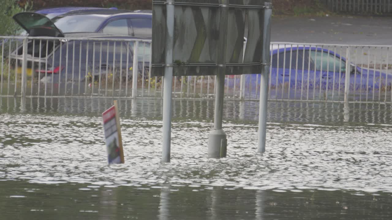 Water Rushing by on Flooded Roundabout with Cars Flooded and Submerged After Heavy Downpour with Road Underwater