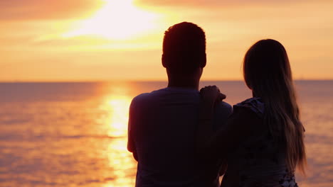 Multi-Ethnic-Couple-In-Love-Admires-The-Sunset-Over-The-Ocean