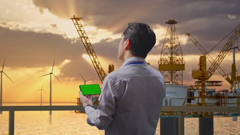 offshore worker using smartphone at sunset