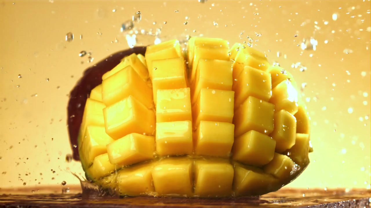 Acqua che schizza su mango fresco a cubetti al rallentatore.