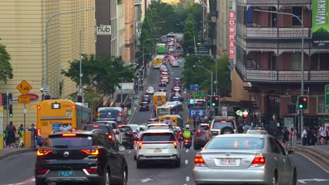 bottleneck traffic on edward street in brisbane central business district during peak hours, with pedestrians crossing, buses and cars driving and running in all directions.