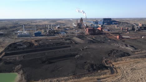 an expansive industrial plant and coal mines during the day, aerial view