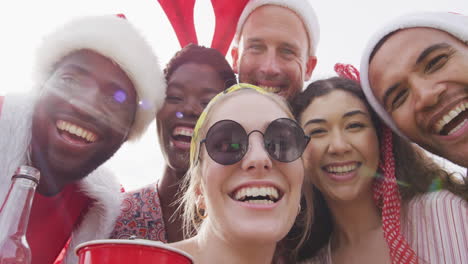 happy group of diverse friends taking selfie at christmas party in garden