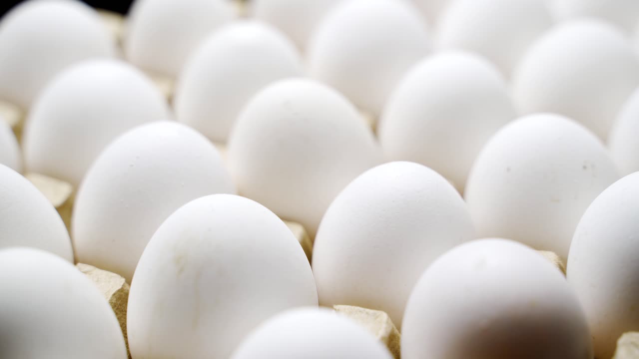 Ovos de galinha branca em uma caixa de papelão. Ovos em uma bandeja de papel.