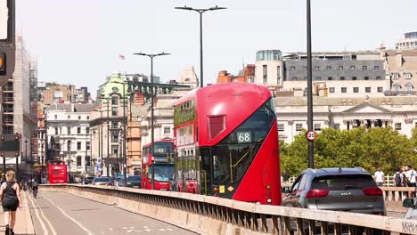 red bus crossing bridge in london, england