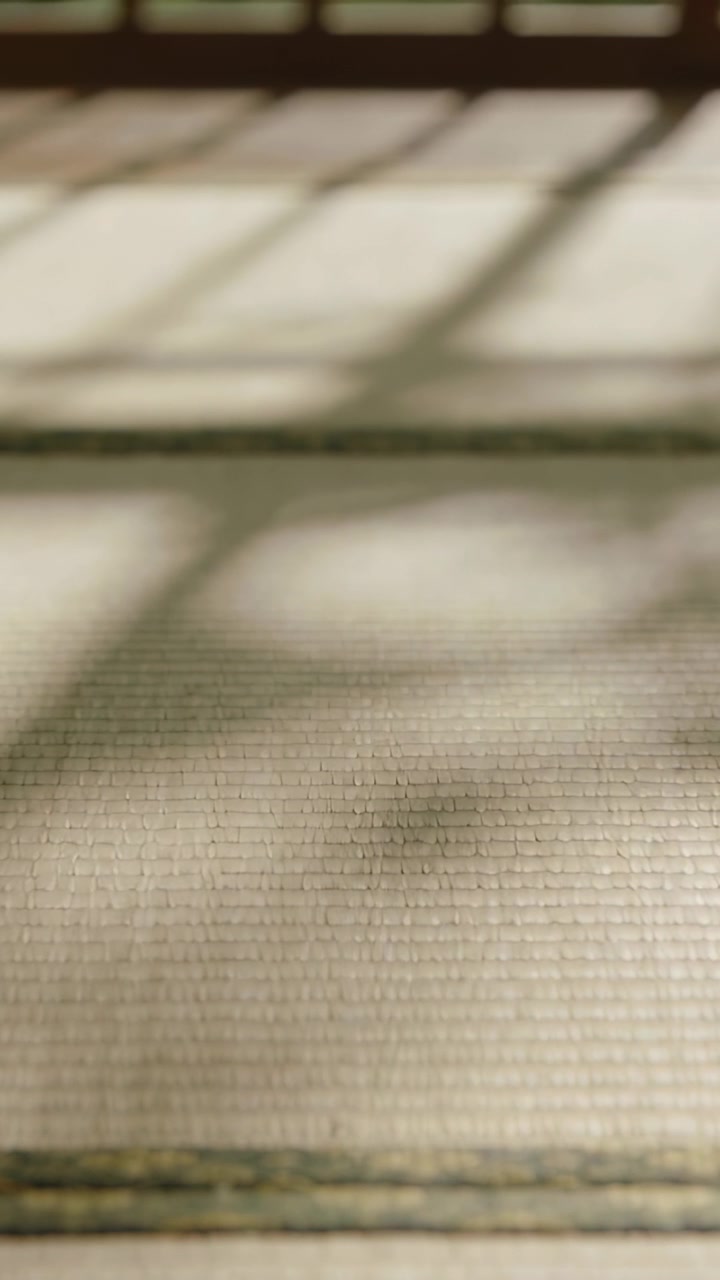 Luce solare che si sposta sul tatami, proiettando ombre a griglia sulla cucitura heri e sul davanzale per l'interior design.