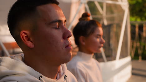 couple meditating in a dome tent at sunset