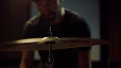 Drummer-hands-installing-cymbal-in-studio.-Musician-twisting-butterfly-nut-screw