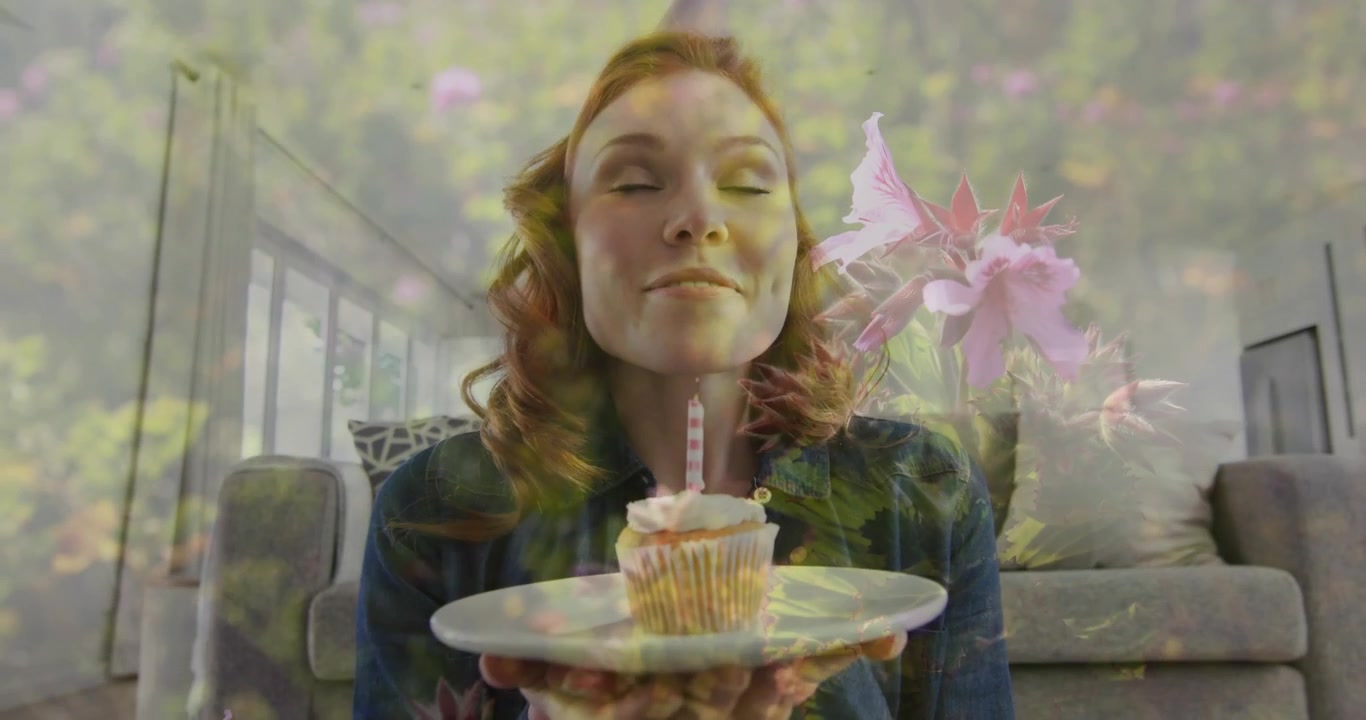Femme pinçant les lèvres, tenant une assiette de cupcake, célébrant en soufflant une bougie avec une superposition florale.