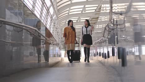 hermosa mujer joven arrastrar equipaje juntos en la ciudad. dama caminando en los caminos viaje de negocios en vacaciones.