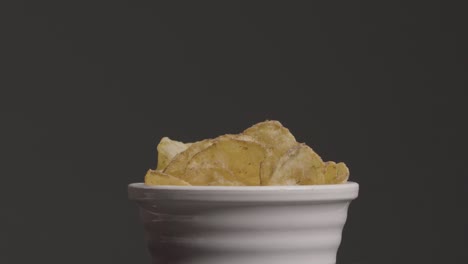 wide shot of hand taking potato chip from bowl