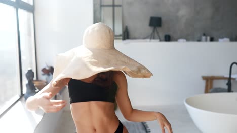 mujer con un sombrero de paja en un baño moderno