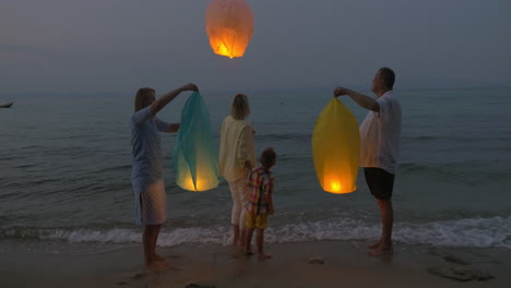 Familie-Fliegende-Himmelslaterne-Am-Strand