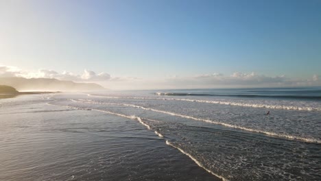 Stunning-smooth-drone-shot-heading-over-ocean-waves-during-sunrise-in-Costa-Rica