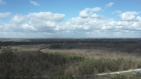 drone-rising-into-sky-over-a-large-landscape-of-Southern-Sweden