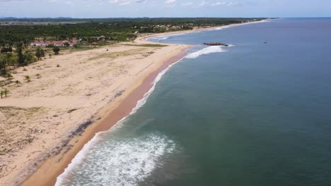 aerial flying across ocean, beach and waves in popular surfing destination of arugam bay, sri lanka