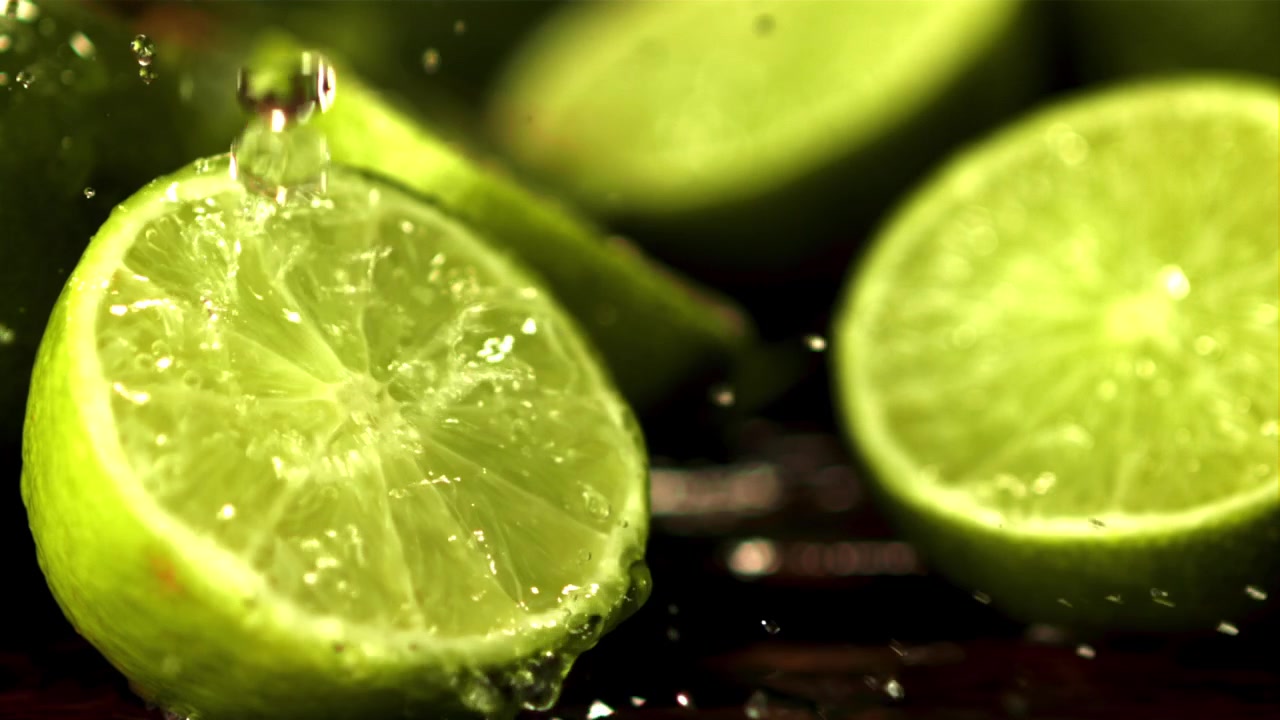 Slow Motion Water Splashing on Fresh Green Lime Halves