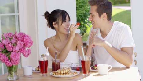 couple feeding each other at breakfast