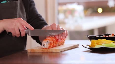 making sushi at home kitchen. woman hands rolling homemade sushi.