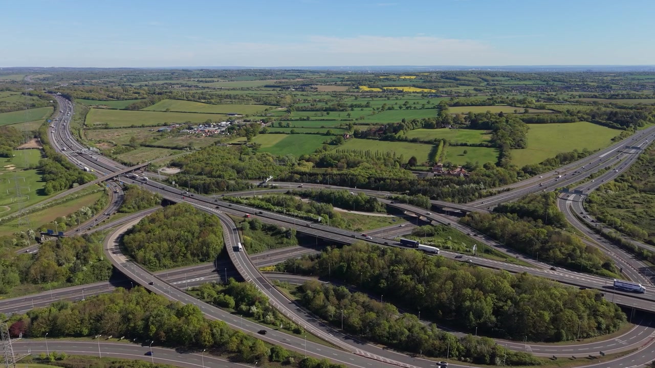 Overhead View of Intricate Motorway Interchange With Busy Traffic in Summer
