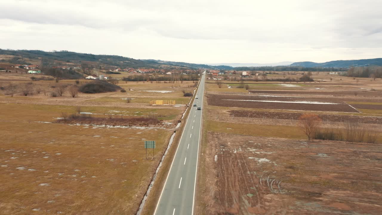 coches en la carretera entre tierra cultivable, drone 4k de color