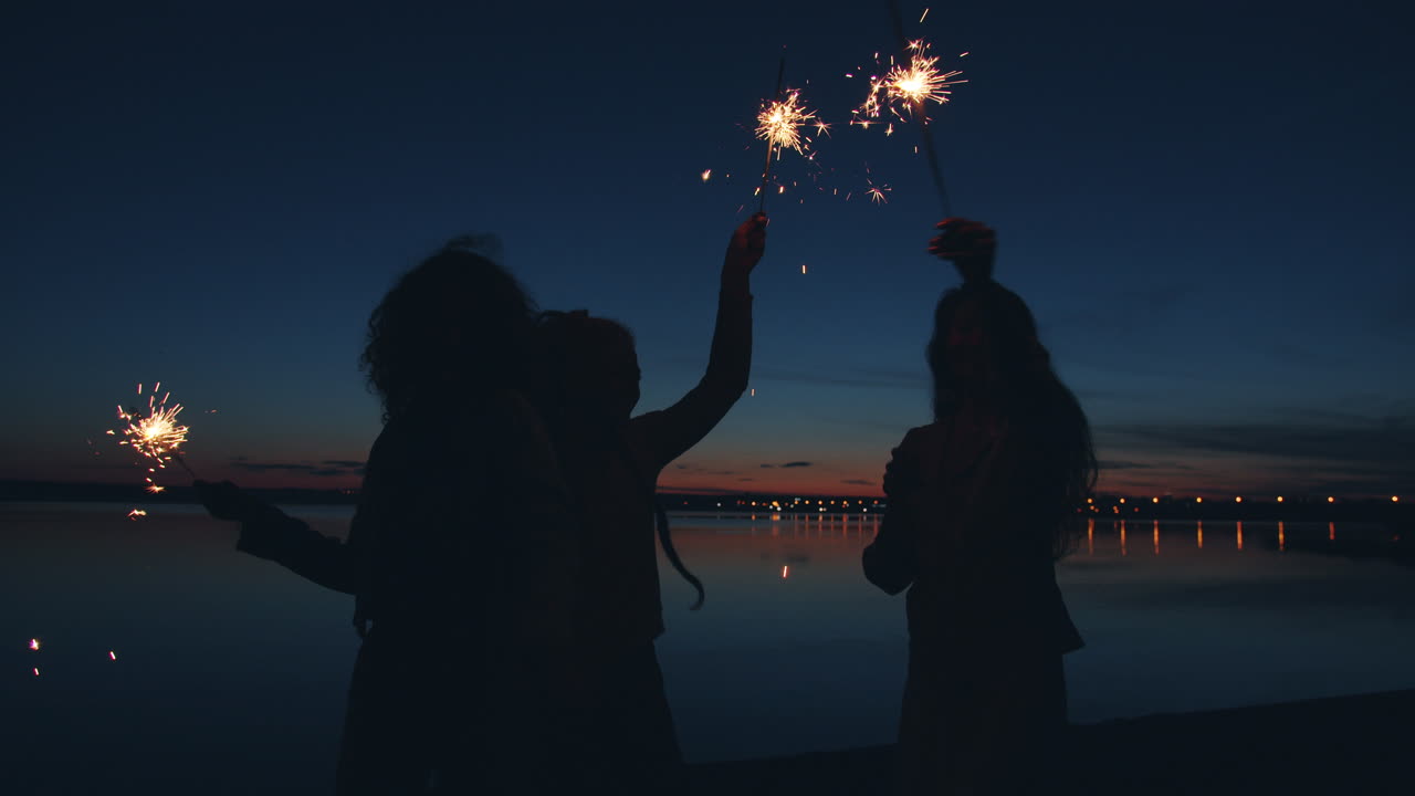Friends Celebrating at Sunset by the Lake with Sparkler