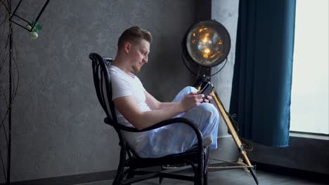 man using phone in a chair