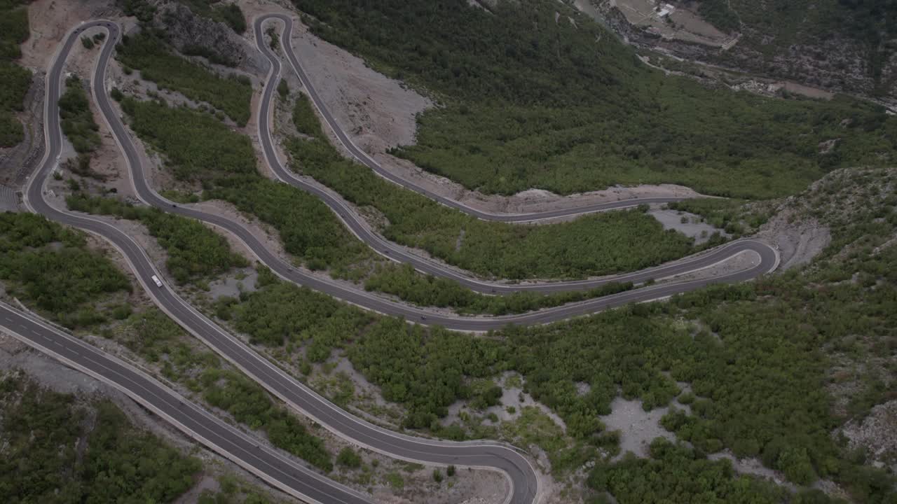 video de drones de una panorámica descriptiva sobre el paso de montaña "rrapsh serpentine" en la carretera sh20 en grabom, albania, se puede ver pasar una motocicleta y un automóvil