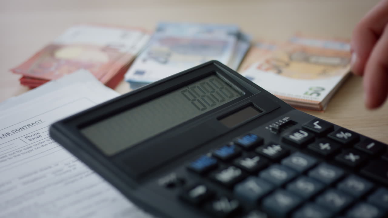 manos presionando números calculadora contando gastos de dinero en la oficina de cerca.