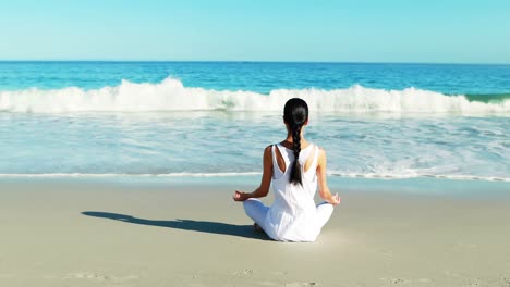 vista trasera de una mujer realizando yoga