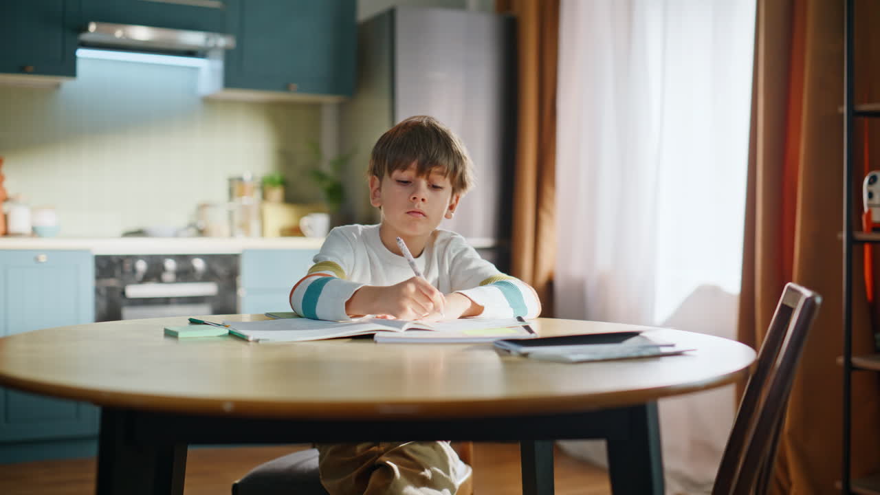 モダンな自宅のキッチンで勉強や宿題をする賢い子供のクローズアップ