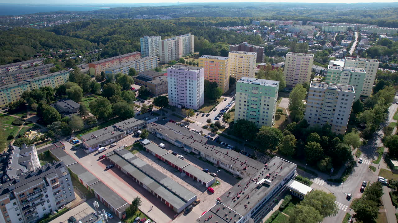 Aerial - residential district close to a natural environment - tall apartment buildings - green trees nearby - Gdynia, Witomino, Poland
