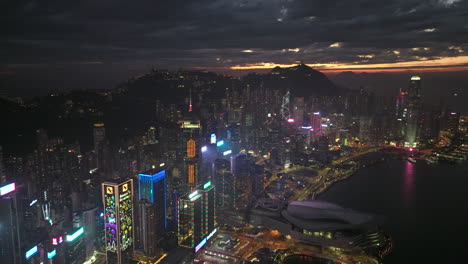 Toma-Aérea-Hacia-Atrás-Del-Centro-De-La-Isla-De-Hong-Kong-Con-Horizonte-Durante-La-Puesta-De-Sol