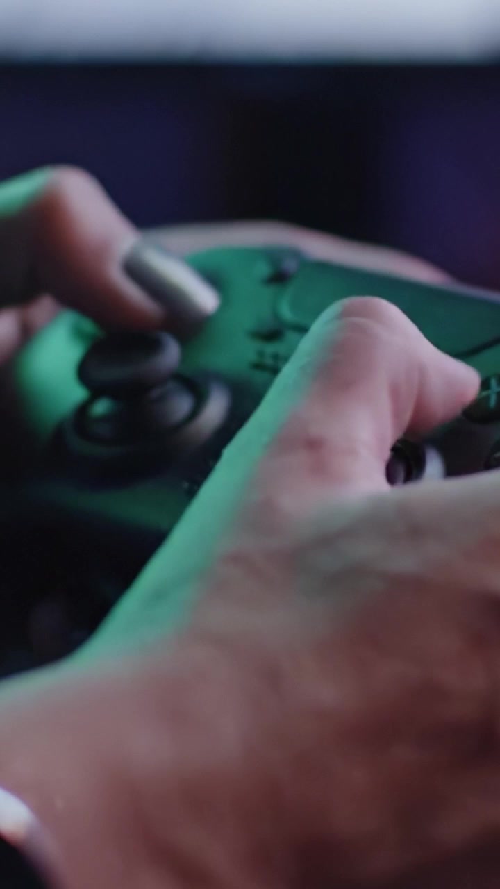 Intense Gaming Moments Captured: A Close-Up Look at Hands Gripping a Game Controller in Dim Lighting, Highlighting the Passion for Play.