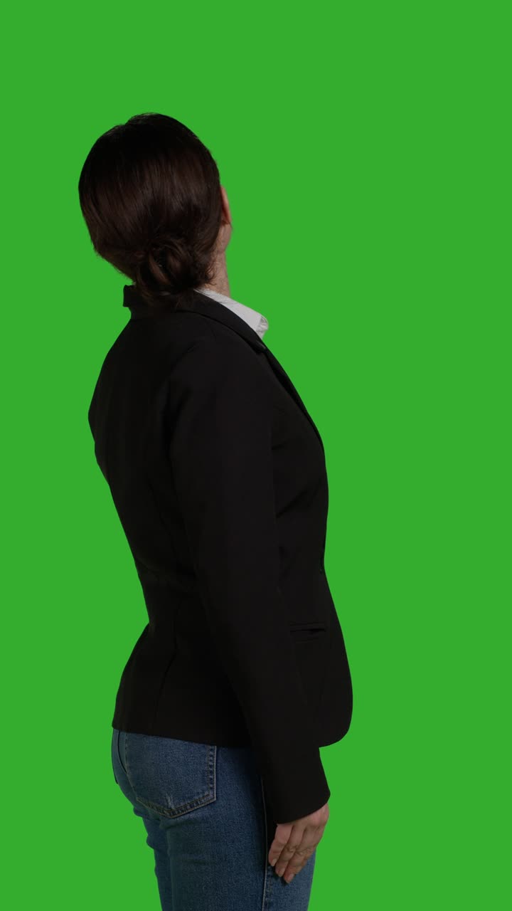 Video verticale: primo piano laterale di una donna d'affari concentrata in piedi su greenscreen