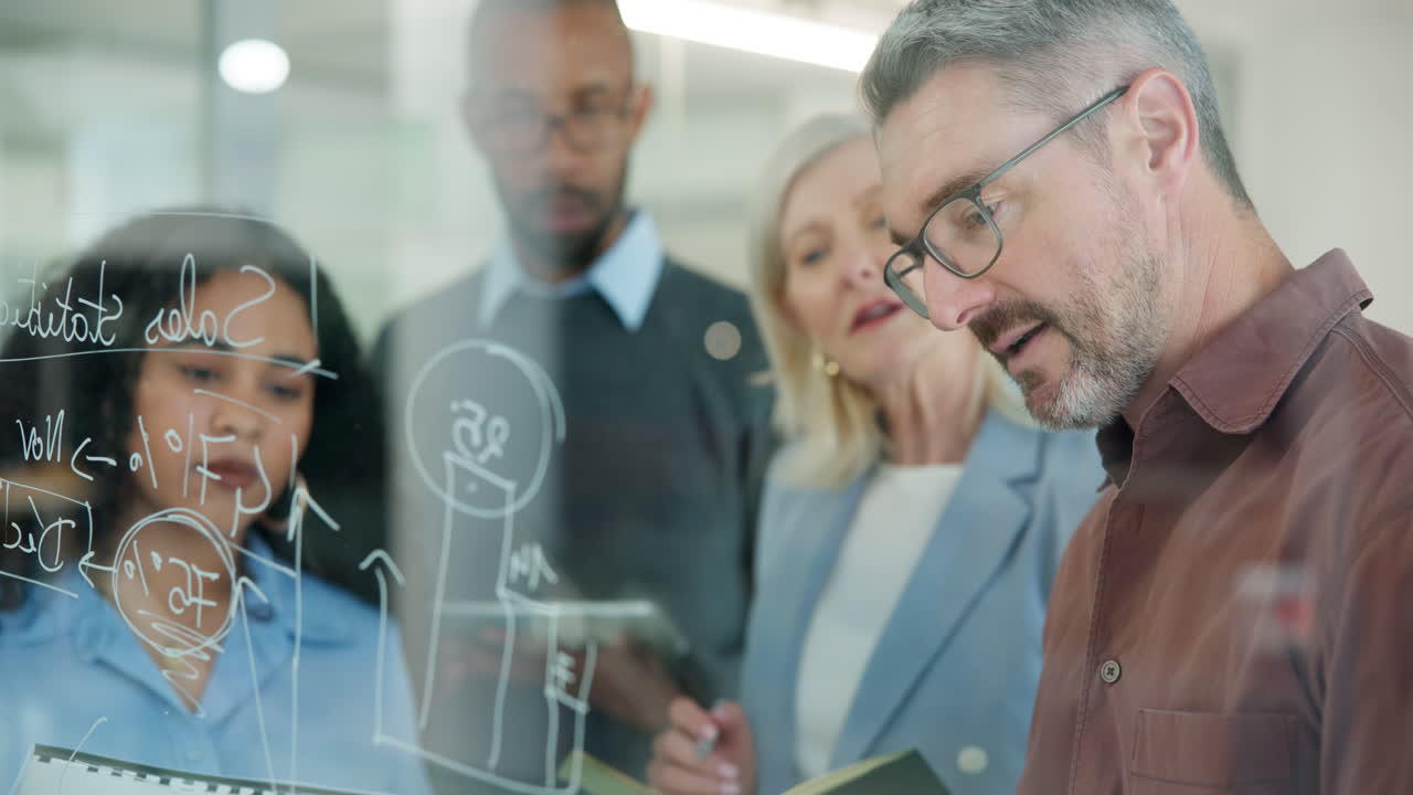Diverse Business Team Brainstorming Ideas on a Glass Board in Modern Office