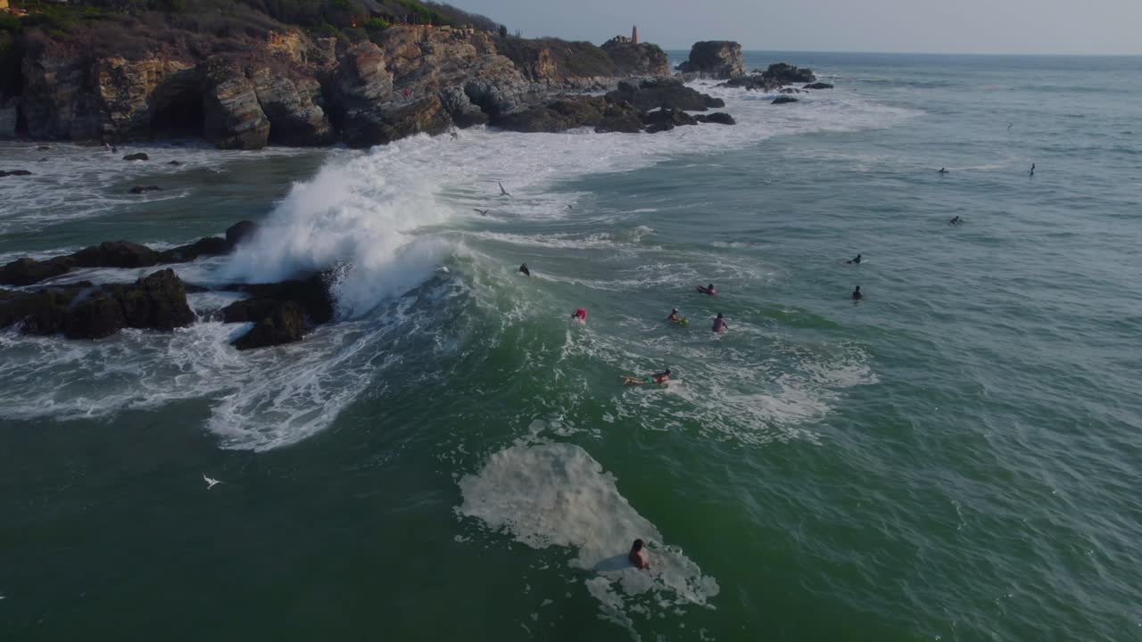olas rompiendo a través de los surfistas esperando la oportunidad perfecta en punta zicatela