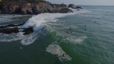 waves crashing through surfers waiting for the perfect opportunity in punta zicatela