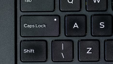 top view finger pressing caps lock button keyboard