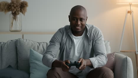 hombre jugando videojuegos en un sofá