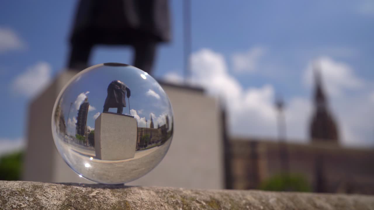 Statue of Winston Churchill in Parliament Square refracted in a glass ball.